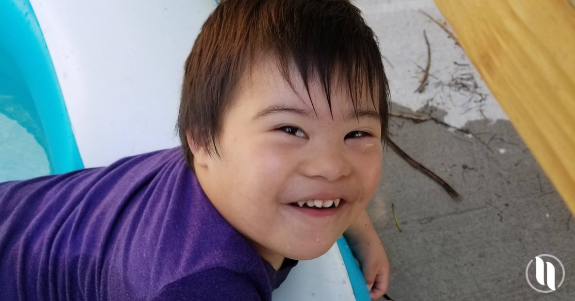 child with down syndrome in pool black hair